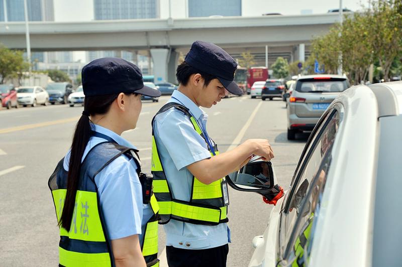 南宁市交通执法支队执法人员检查网约出租车相关证件.