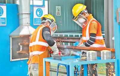 在马东铁项目铺轨基地，工人们正在焊接长钢轨。以上图片均为人民日报记者刘慧摄
