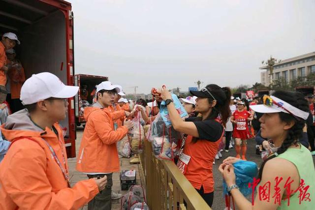 4月14日，北京天安门广场，志愿者正在为跑者们存包。中青报·中青网记者 陈剑／摄