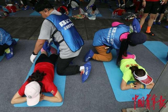 4月14日，北京奥林匹克公园附近，结束比赛后的跑者进行拉伸放松。中青报·中青网记者 陈剑／摄