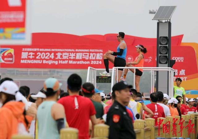 4月14日，北京天安门广场， 健身教练在平台上带领众多跑者做准备活动。中青报·中青网记者 陈剑／摄