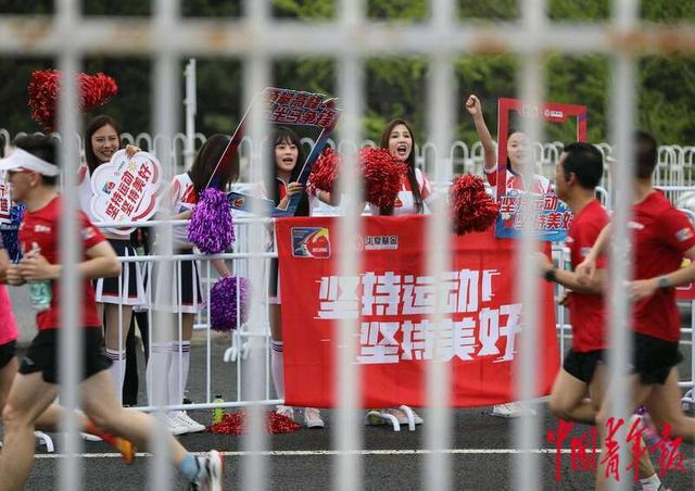 4月14日，北京北四环附近，拉拉队员为经过的跑者们加油。中青报·中青网记者 陈剑／摄