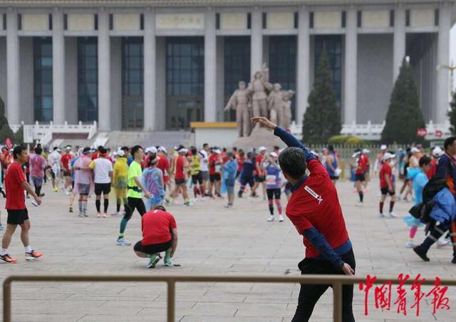 4月14日，北京天安门广场，一位跑者在毛主席纪念堂前做准备活动。中青报·中青网记者 陈剑／摄