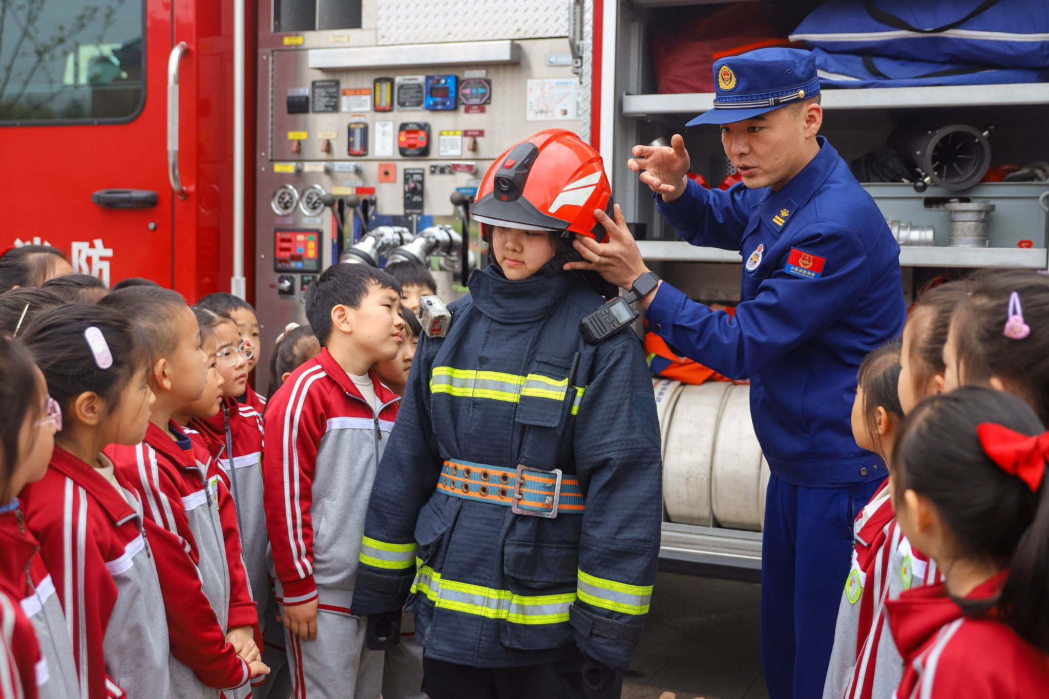 张鹰 摄4月15日,在青岛徐水路小学,消防员指导学生使用灭火器灭火.