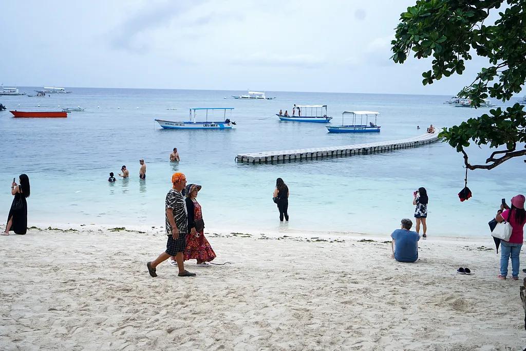 游客在菲律宾保和岛海滩边游玩 资料图 中新社记者 张兴龙 摄