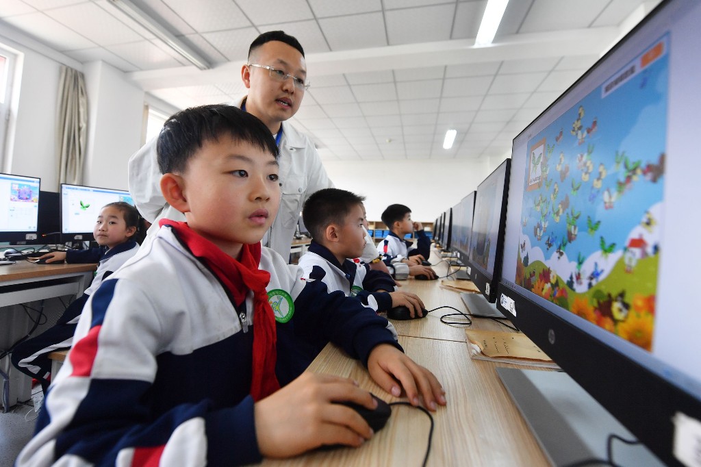 4月18日，老师在“科技课堂”上指导学生练习图形编程。王海滨 摄