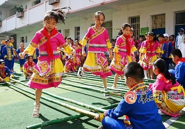 2023年5月30日，罗城仫佬族自治县第二小学举行民族传统体育运动会，学生们穿上民族服装跳竹竿舞。蒙增师 韦如代 摄