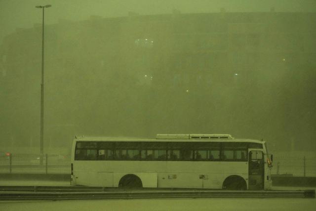 当地时间2024年4月16日，阿联酋迪拜，一辆公交车停在倾盆大雨中，天空变成了绿色。本文图片均为 视觉中国 IC 图