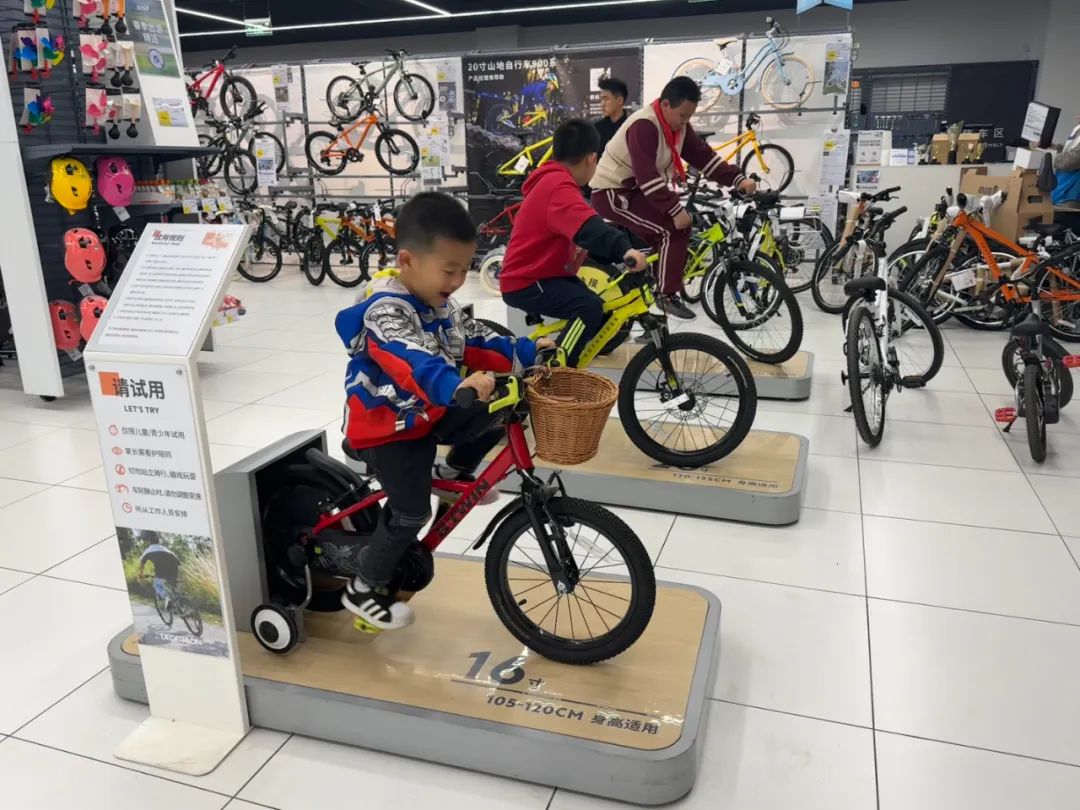 孩子们在运动卖场自行车区体验骑行的快乐。