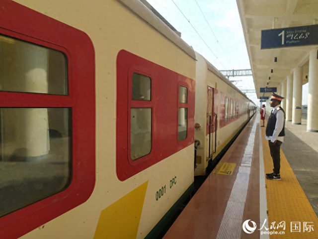 站台工作人员正在目送列车驶离车站。人民网记者 黄培昭摄