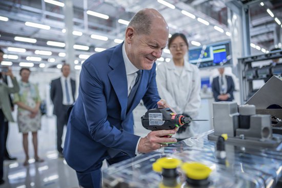     4月14日，重庆，德国总理朔尔茨参观博世公司氢动力系统生产基地时，为完成预装的氢动力模块拴紧最后一颗螺丝。视觉中国供图