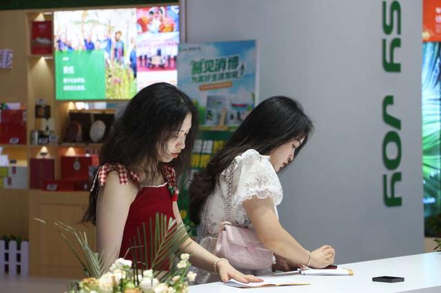 两位女生在收集消博会的印章。黄丹丹/摄