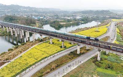 图为首发的“熊猫专列·什邡号”旅游列车行驶在青山绿水间。本报记者 王明峰摄
