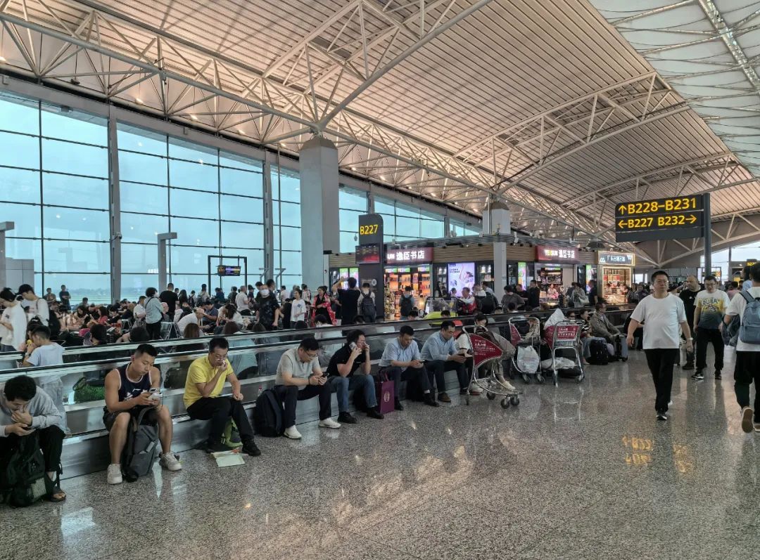 △19日，广州白云机场，暴风雨天气影响导致航班大面积延误取消，候机厅旅客众多。
