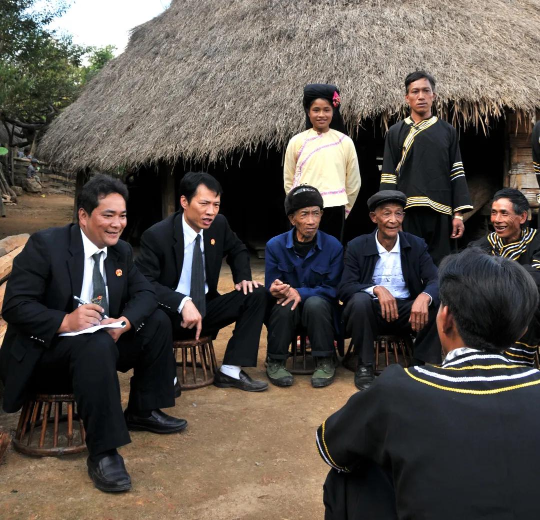 鲍卫忠（左一）在云南省沧源县勐角乡控角村委会小坝卡自然村巡回办案。云南省高级人民法院 供图