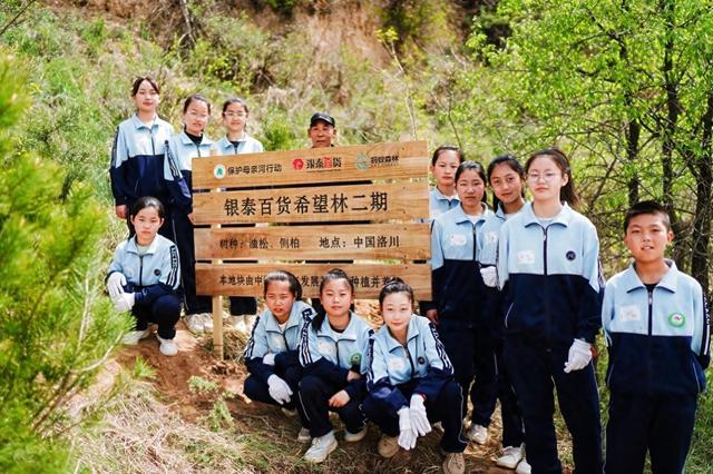 图为：现场参与“银泰百货希望林”植树活动的洛川县菩提镇小学生们