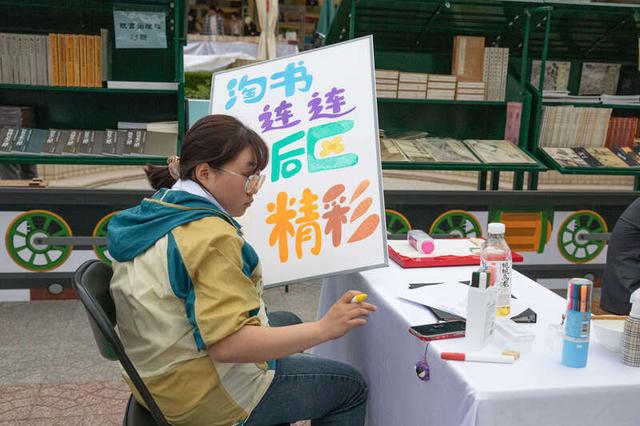 4月19日,北京朝阳公园,2024年北京书市上,中国书店的工作人员在绘制
