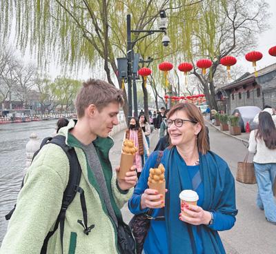 4月初，利用免签政策赴华旅游的比利时游客在北京后海品尝小吃。梵尚·沃姆摄