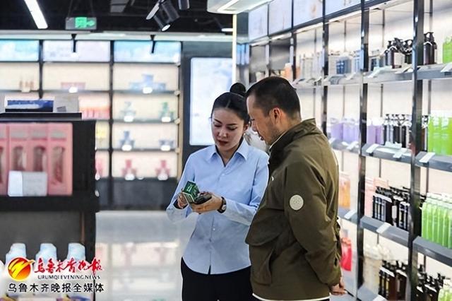 　　4月22日，在美林购跨境保税购物体验中心，工作人员在给顾客介绍商品。记者米热扎提·木塔力甫摄
