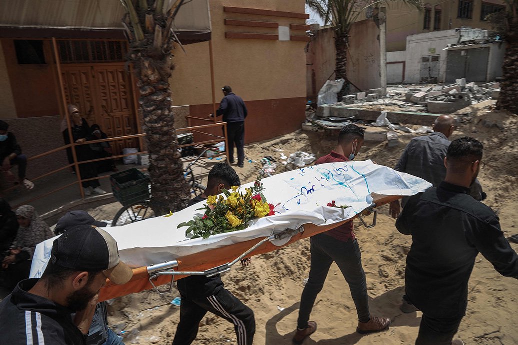 当地时间2024年4月23日，加沙地带南部汗尤尼斯，工作人员在纳赛尔医院运送尸体。
