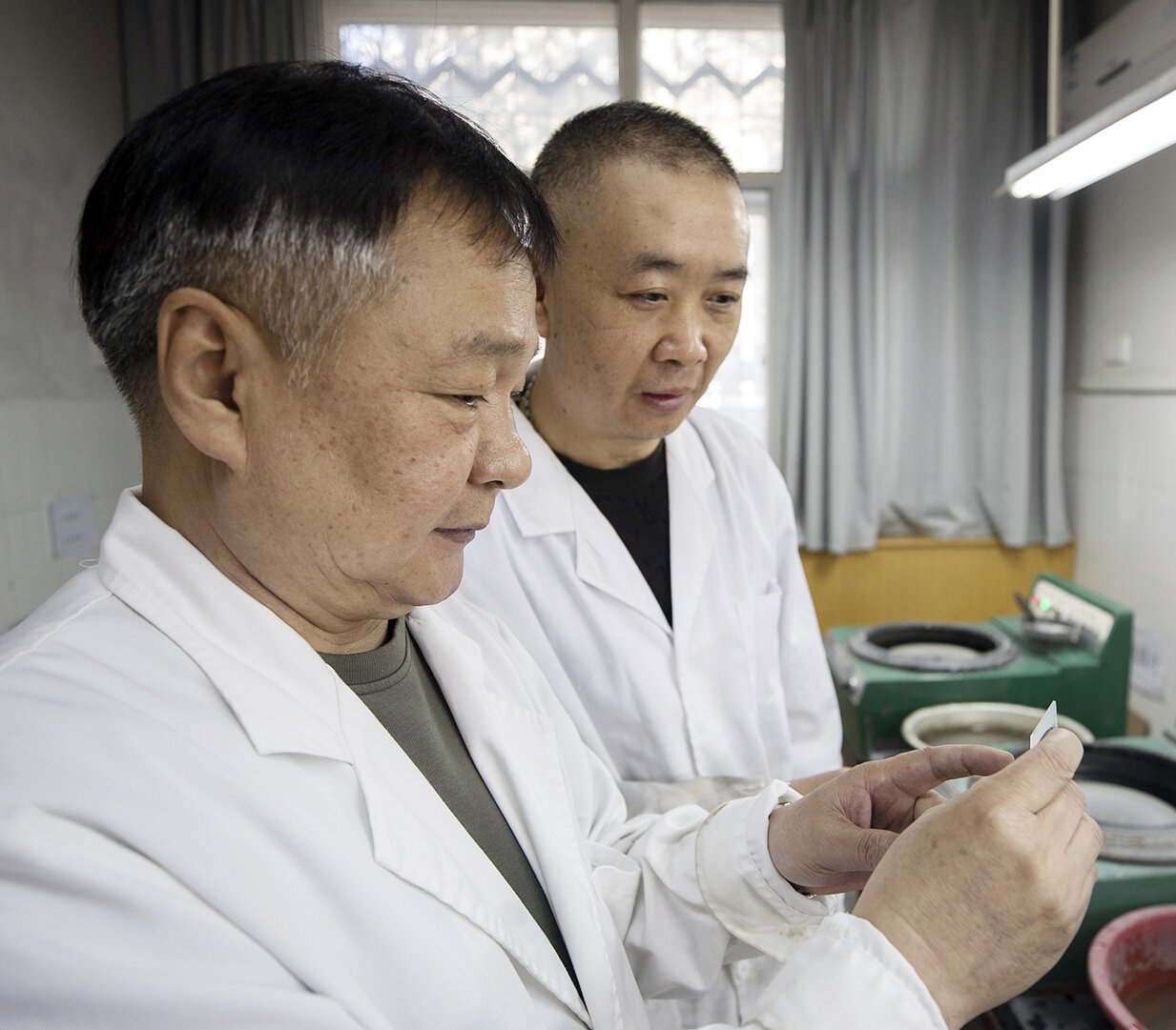 李裕杰（左）和同事在交流石片制作经验。（张睿 摄）