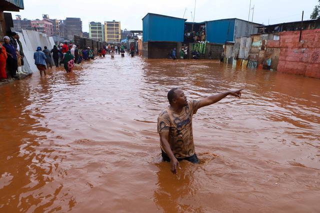 4月24日，在肯尼亚内罗毕马萨雷贫民区，一名男子在洪水中前行。新华社发（乔伊·纳布科瓦摄）