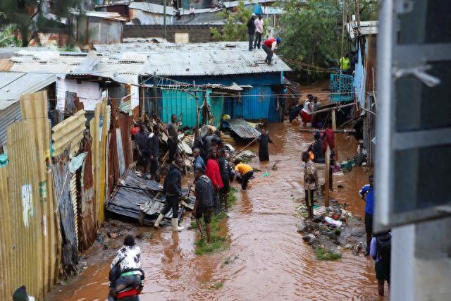 4月24日，在肯尼亚内罗毕马萨雷贫民区，人们查看因洪水受损的房屋。新华社发（乔伊·纳布科瓦摄）