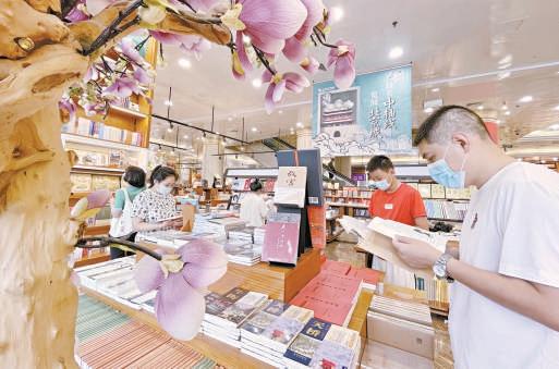 读者来到王府井书店阅读有关北京中轴线、京城历史文化和人文风情主题的图书。 方非摄