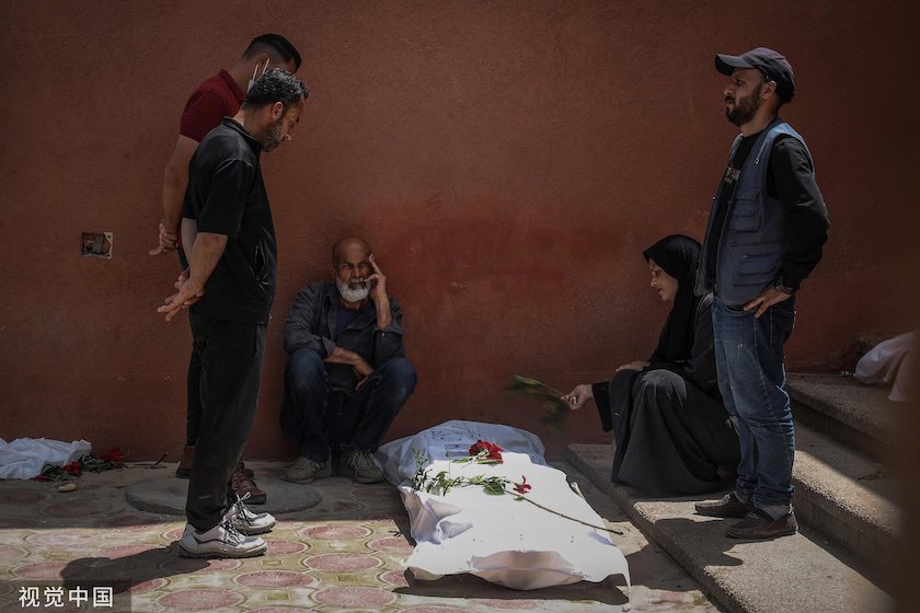4月23日，加沙地带南部汗尤尼斯的纳赛尔医院，民众在挖掘出的亲人尸体旁哀悼。图片来源：视觉中国