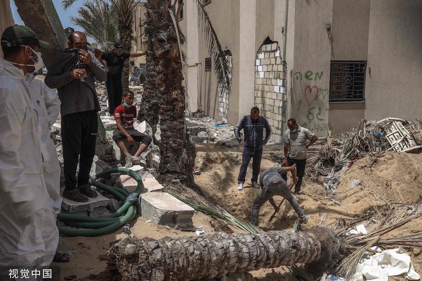 4月23日，加沙地带南部汗尤尼斯的纳赛尔医院，民众和医务人员正在挖掘尸体。图片来源：视觉中国
