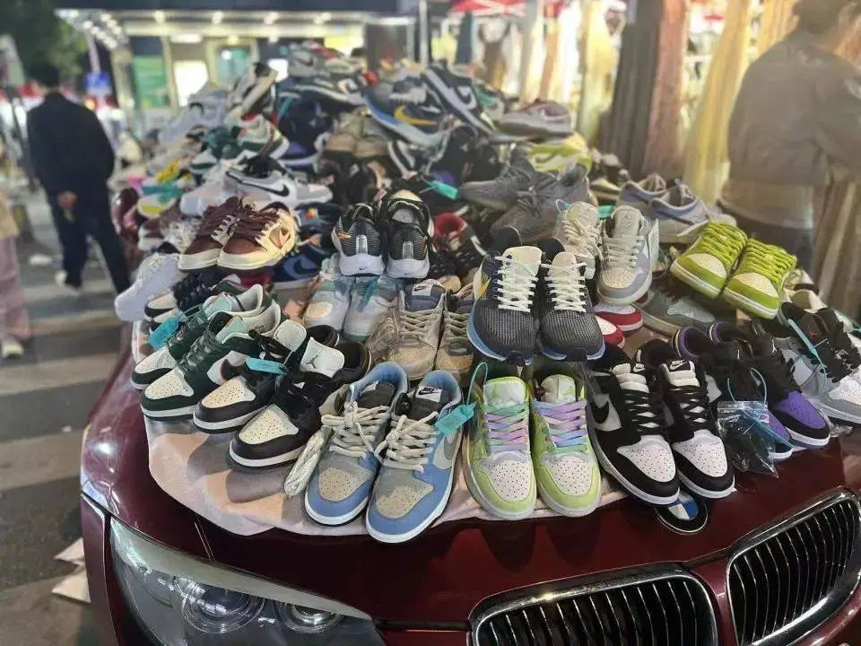 △ 义乌夜市里，宝马车上摆着运动鞋。（图源：时代周报记者 刘沐轩/摄）