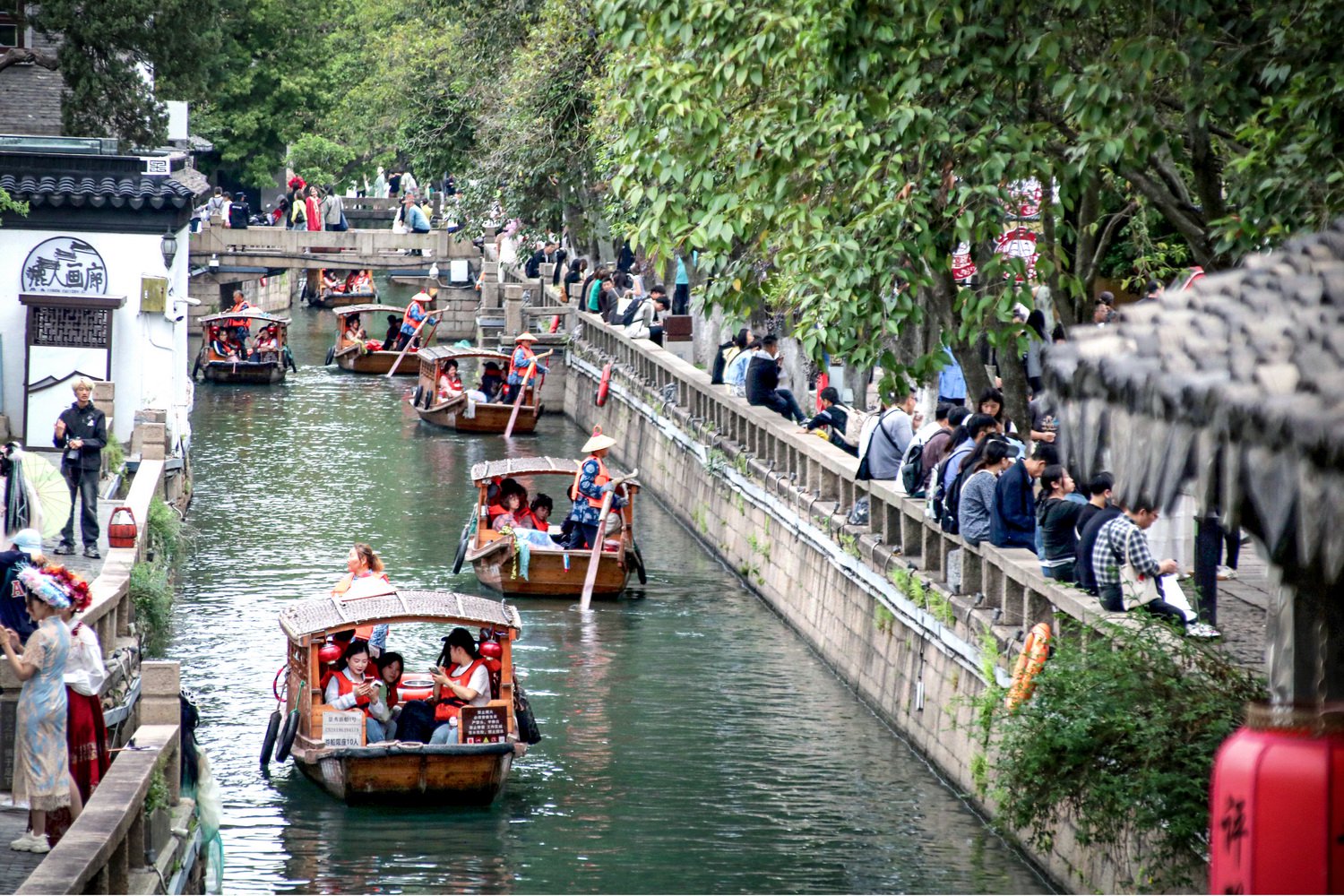 4月26日，江苏苏州，游客乘坐手摇小木船在平江路水巷游玩。