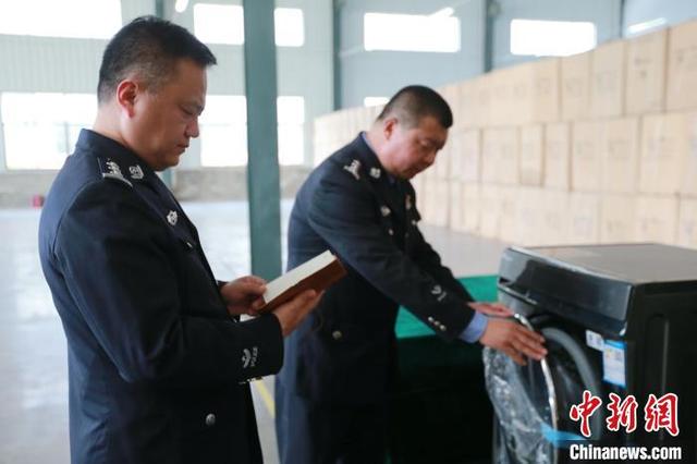 4月18日，民警正在巨野县一仓库内查验涉案洗衣机。梁犇 摄