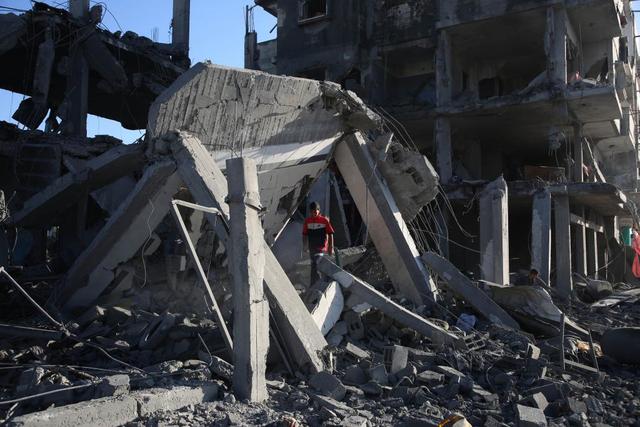 4月20日，在加沙地带南部城市拉法，巴勒斯坦人查看被以军空袭的建筑。新华社发（哈立德·奥马尔摄）
