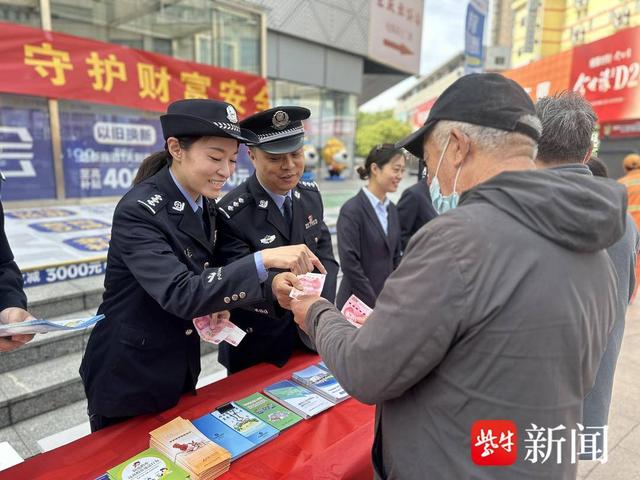 图为民警联合多方进行反假币普法宣传