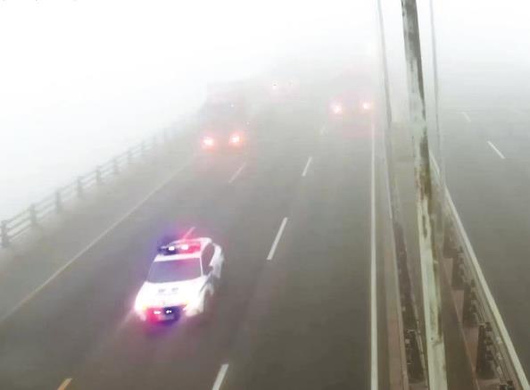 迷雾中，警车开道、限速压道、批次放行，保障数万车辆安全通过东海大桥 受访者供图