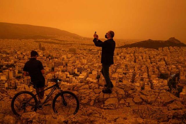 4月23日，希腊雅典遭遇来自非洲撒哈拉沙漠的沙尘侵袭，城市上空变成橙黄色，楼房和街道笼罩在沙尘之中。视觉中国供图