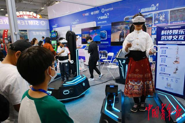 4月27日，北京首钢园，第八届中国科幻大会“潮幻奇遇季”活动展区，一名身着马面裙的参观者正在体验VR跑步机。田嘉硕/摄