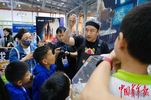4月27日，北京首钢园，第八届中国科幻大会“潮幻奇遇季”活动展区，小朋友们正在围观科学实验。田嘉硕/摄