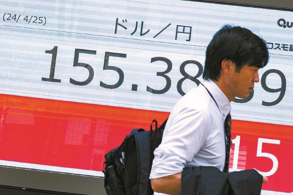 行人走过日本东京一处显示实时汇率的电子屏幕 新华社 发