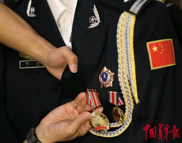 2024年4月28日，北京，大北照相馆前门店，一位劳模代表在整理制服胸前的奖章。中青报·中青网记者 陈剑/摄
