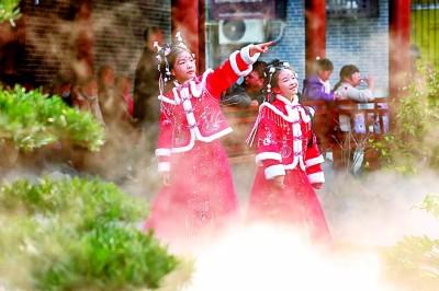 两位身着传统服饰的小游客在襄阳古城游玩。杨东摄