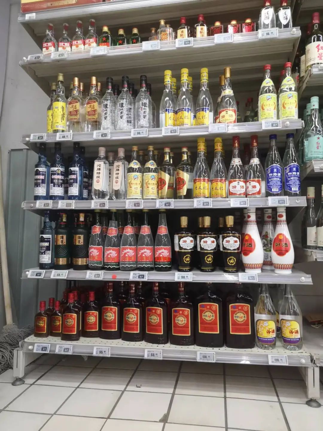 有"蓝帽子"标识的劲酒摆放在物美超市增光路店的酒水货架上.孟刚/摄