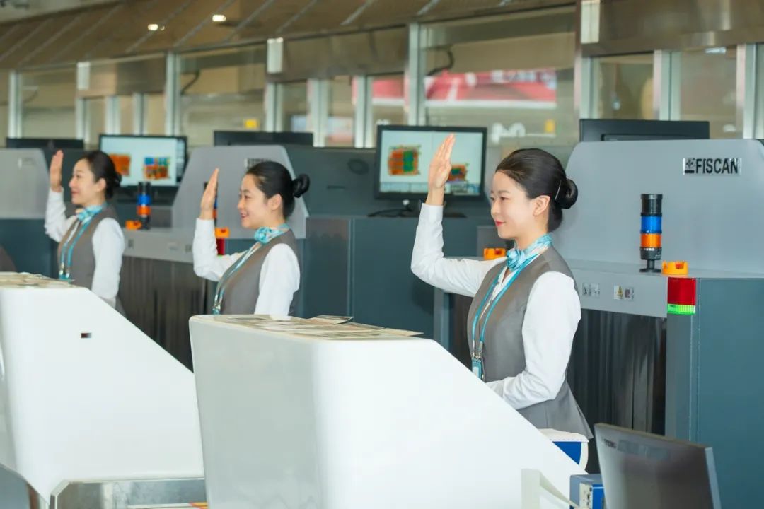 海口美兰国际机场2号航站楼内值机员为旅客办理值机手续