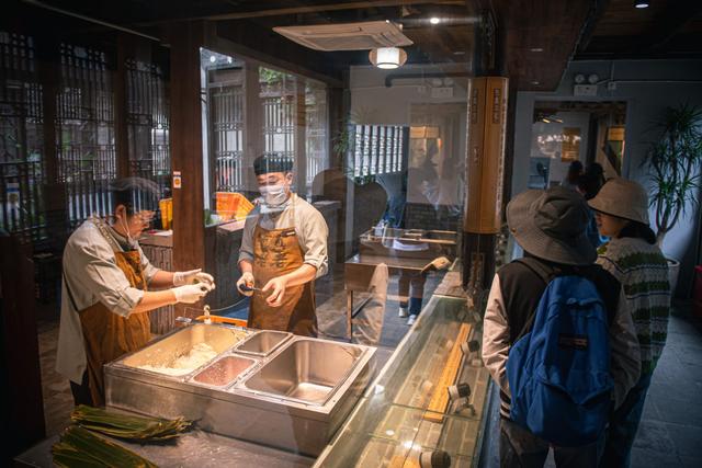 4月26日，游客在嘉兴市月河历史街区嘉兴粽子文化博物馆参观粽子制作过程。新华社记者 江汉 摄