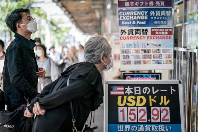 4月25日，日本东京，行人在一家货币兑换店外查看日元兑美元的汇率。