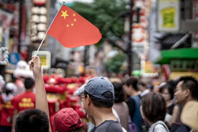 2023年10月1日，日本横滨唐人街，一名男孩手举中国国旗。
