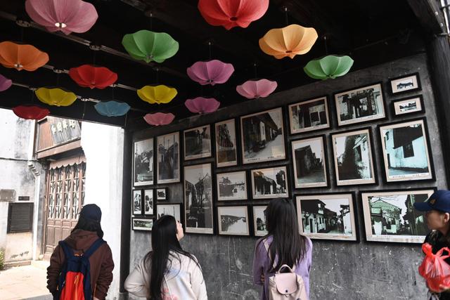 4月26日，游客在月河历史街区观看街区老照片。新华社记者 黄宗治 摄