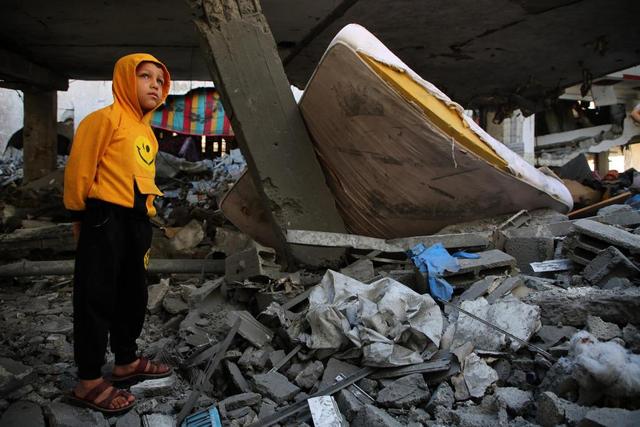 4月17日，在加沙南部城市拉法，男孩站在遭以军空袭的住宅废墟上。新华社发（哈立德·奥马尔摄）