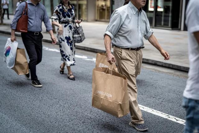 2023年10月1日，日本东京，中国国庆假期期间，中国游客提着购物袋走在银座街道。